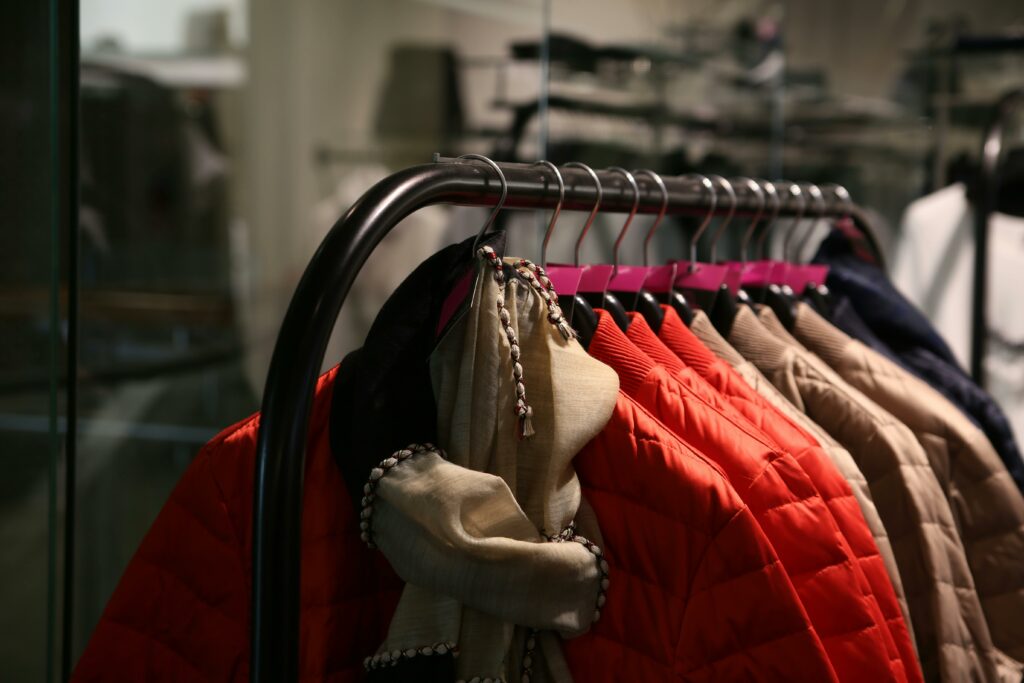 A variety of colorful jackets hanging on a clothes rack in a stylish store.